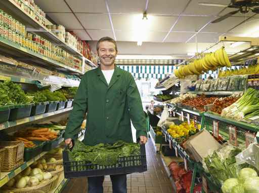 grocer carrying some fresh vegetables